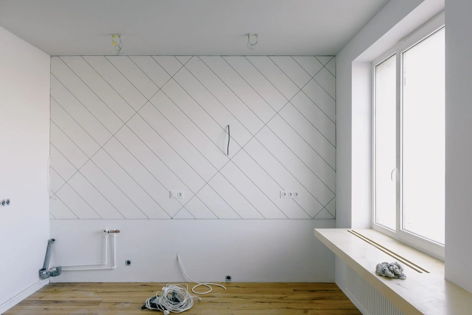 Lege kamer met afgeplakte lijnen op de wand en een groot raam